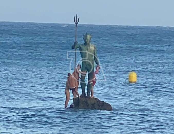 Jóvenes aficionados del Atlético de Madrid se acercaron hasta la escultura para ponerle una bufanda rojiblanca/TA.
